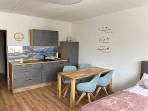 a kitchen with a wooden table and blue chairs at SeenSucht 2 " Neu renoviert " in Strobl
