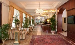 a lobby with couches and a chandelier at Grand Hotel Gallia in Milano Marittima