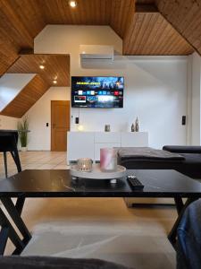 a living room with a table and a tv at Ferienwohnung am Stadtwald in Wassenberg