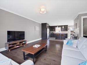 a living room with a white couch and a coffee table at Comfortable 3BR Getaway in Riverview
