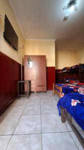 una camera con due letti e una TV a schermo piatto di Hospedaje Artigas a Corrientes