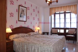 a bedroom with a bed with pink floral wallpaper at Casa Rural Maribel II in Cue