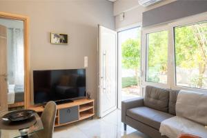 a living room with a couch and a flat screen tv at Aether houses in Mytilene