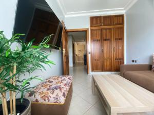 a living room with a couch and a wooden bench at Comfortable & Well-Located Apartment Near Rabat in Oulad Akkou