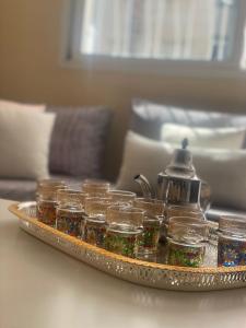 a tray of glass jars on a table at Comfortable & Well-Located Apartment Near Rabat in Oulad Akkou
