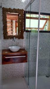 un bagno con lavandino e doccia in vetro di Chalé ponta negra paraty a Parati