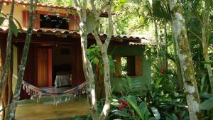 una casa verde con un'amaca di fronte di Chalé ponta negra paraty a Parati