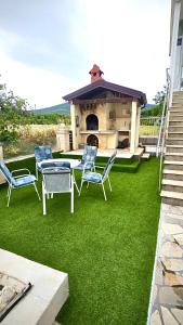 a lawn with chairs and a table and a fireplace at Villa Forever More in Kaštela +8 photos
