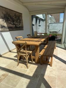 a wooden table and bench on a patio at L œil de sangatte in Sangatte