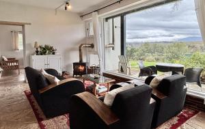 a living room with a couch and chairs and a fireplace at Elgin Views with Hot Tub in Ouda Brug