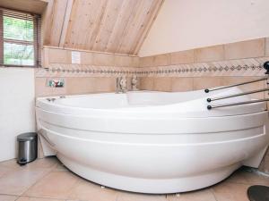 a white tub in a bathroom with a wooden ceiling at 5 person holiday home in Ringkøbing-By Traum in Nørby +29 photos