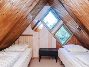 two beds in a room with wooden walls and windows at 5 person holiday home in Ringkøbing-By Traum in Nørby