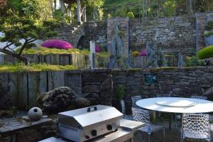 un gril posé sur une table dans un jardin dans l'établissement Maison Contemporaine Bien être Jacuzzi Hammam et Art immersif dans un cadre zen proximité Mont Saint Michel, à Saint-James