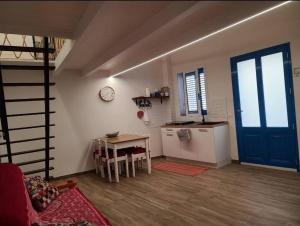 a room with a table and a kitchen with a clock at Appartamento Nonno Pit, Marettimo in Marettimo +3 photos