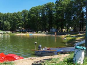 a couple of boats sitting in the water at Rusałka Domki Rodzinne in Rudno