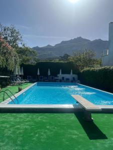 a swimming pool with a bench in a yard at Perla Bianca Holiday Home, Forio in Ischia