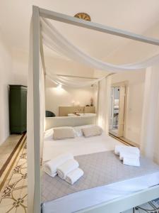 a bedroom with a large white bed with white pillows at Essenze di Puglia - Holiday Rental in Conversano