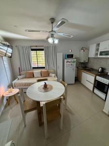 a kitchen and living room with a table and a couch at SORRENTO Céntrico con cochera in Villa Carlos Paz