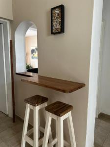 a counter with two stools in a room at Lōla Beach House - Playa Unión in Playa Unión
