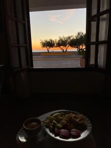 a plate of fruit on a table in front of a window at Lōla Beach House - Playa Unión in Playa Unión