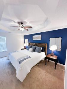 a blue bedroom with a bed and a ceiling fan at Crescent Gardens-3 Miles from UA in Tuscaloosa