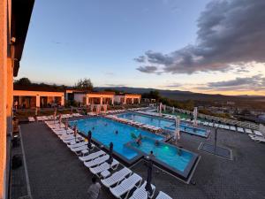 a large swimming pool with chairs and people in it at Modern House in Solotvyno
