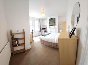 a bedroom with a bed and a desk with a television at Oxford Exclusive Room Art in Oxford