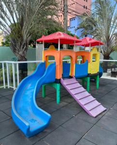 a playground with a slide and a play structure at SPAZIO GOMES E COSTA vip in Cabedelo