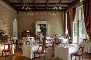 a dining room with white tables and chairs at Ciekocinko Powozownia in Ciekocinko