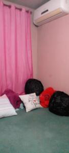 a room with three pillows and a pink curtain at cris Gomes cop30 in Ananindeua