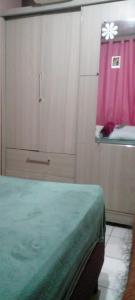 a bedroom with a bed and a window with a pink curtain at cris Gomes cop30 in Ananindeua +2 photos