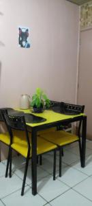 a table with two yellow chairs and a table with a plant at cris Gomes cop30 in Ananindeua
