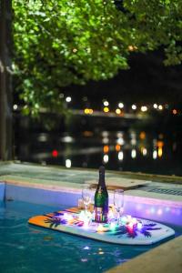 a bottle and glasses on a tray in a swimming pool at Riverside Private Pool&Halal Suite in Shkodër +18 photos