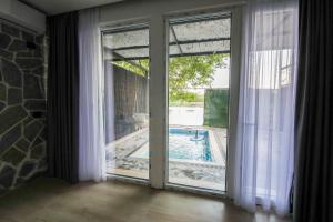 a sliding glass door with a view of a swimming pool at Riverside Private Pool&Halal Suite in Shkodër