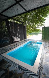 a swimming pool with a hammock and a swing at Riverside Private Pool&Halal Suite in Shkodër