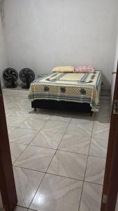 a bed sitting on a tiled floor in a room at Recanto SB in Campo Limpo