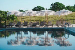 a group of chairs sitting next to a swimming pool at Lemon Suites & Restaurant in Korucuk +14 photos