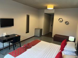 a bedroom with a bed and a desk and a television at Pilar Suites by Viva in Pilar
