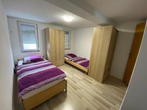 een kleine kamer met twee bedden en een raam bij WgCetin in Göppingen