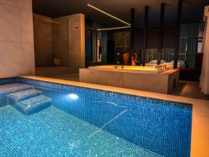a large swimming pool in a bathroom with a bath tub at Motel Paris - Fushë Kosovë in Vragolija