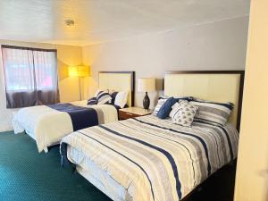 a hotel room with two beds and a window at St. Mary’s Motel in Saint Marys