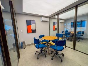 a conference room with a table and blue chairs at Studio 600m da praia in Fortaleza +54 photos