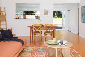 un soggiorno con un divano e un tavolo di Serena Cottage - Sunlit Escape by Woy Woy Bay Wharf a Woy Woy