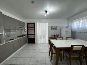 una cucina con tavolo e sedie e una cucina con frigorifero di Apartamento novo e aconchegante a Bento Gonçalves Altre 9 foto