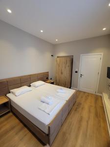 a bedroom with a large bed with towels on it at Te BUNKERI in Ersekë +5 photos