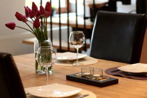 een tafel met twee glazen en een vaas met rode bloemen bij Haus Winkelchen in Cochem