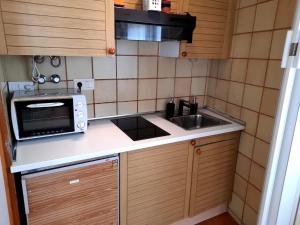 a small kitchen with a sink and a microwave at Canet playa in Canet de Mar