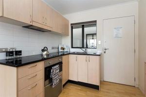 kuchnia z kuchenką górny piekarnik obok drzwi w obiekcie Newmarket Apartment - Queen Bed with Private Bathroom, Free Parking Provided w Auckland