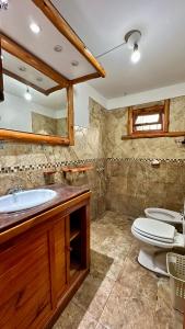 a bathroom with a sink and a toilet and a mirror at Complejo bosque del peñon in Casa Grande
