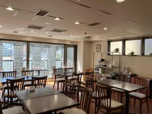 a dining room with tables and chairs and windows at Sapporo Clark Hotel in Sapporo